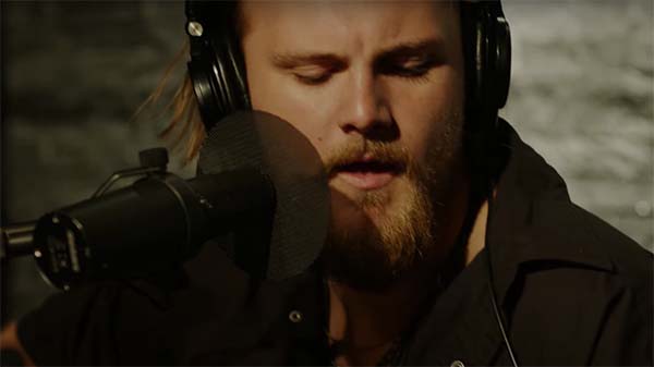 Jackson Dean playing guitar in a recording studio